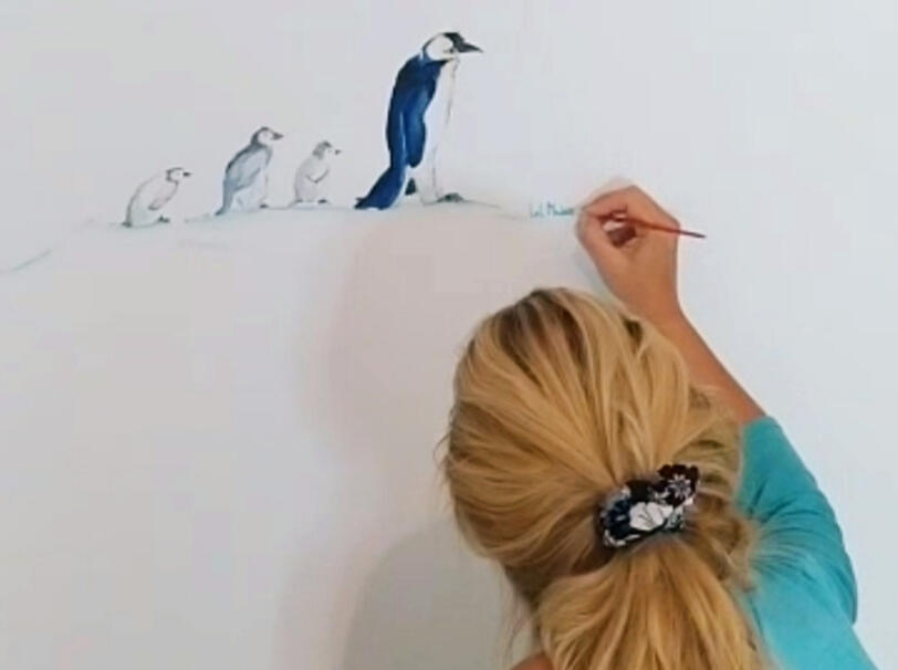 Lol Malone pinta y firma el mural de la habitación del bebé, junto a la familia de pingüinos en Madrid.