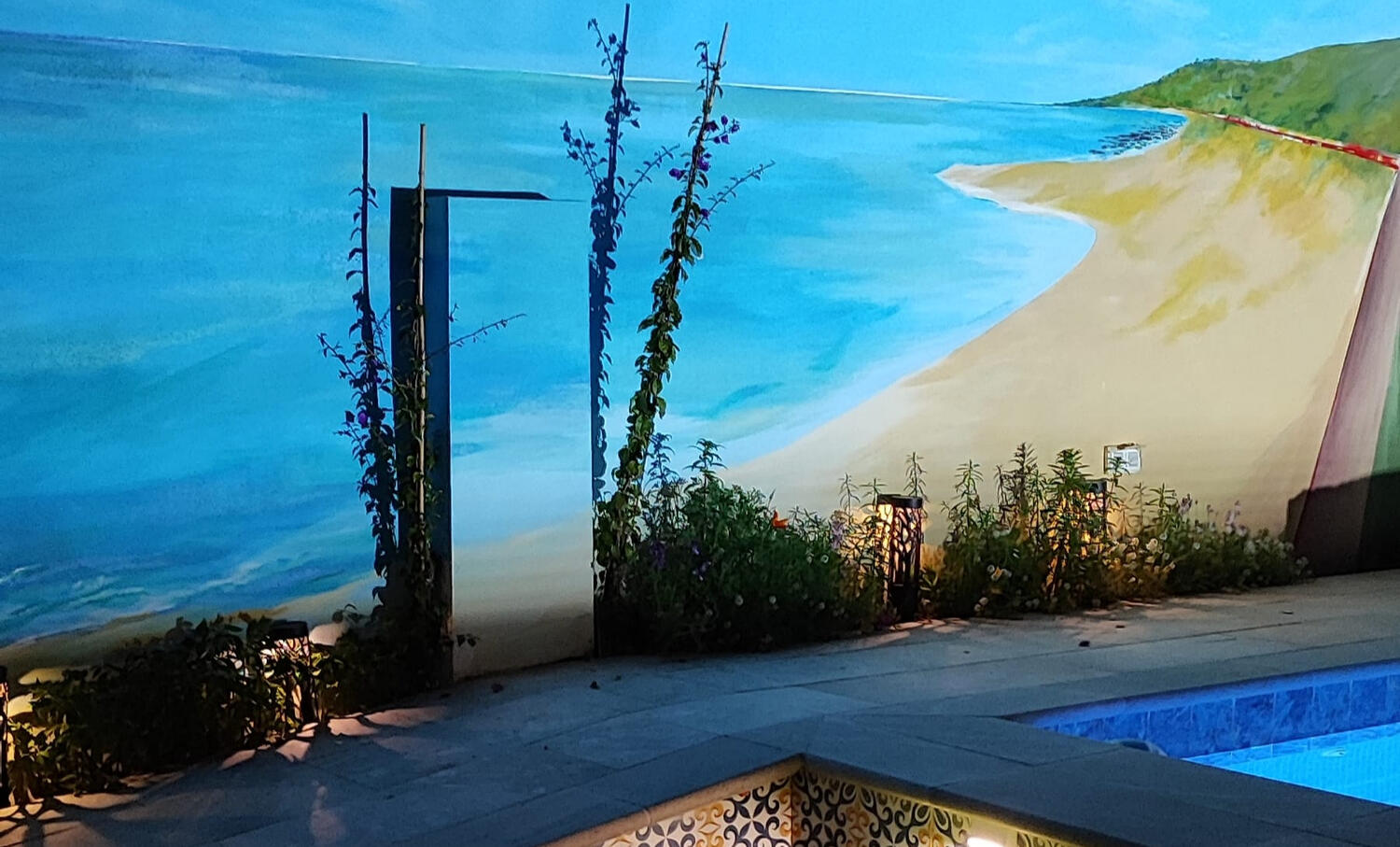 Mural Playa en la noche Pintura mural pintado a mano. Una playa y un cielo azul junto a la piscina iluminada durante la noche